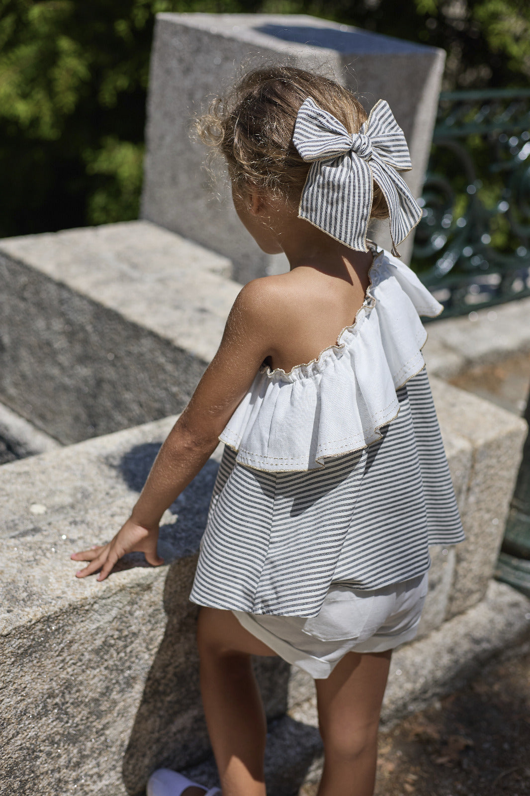 Blusa asimétrica Coffee con volante blanco combinada con pantalón corto blanco niña