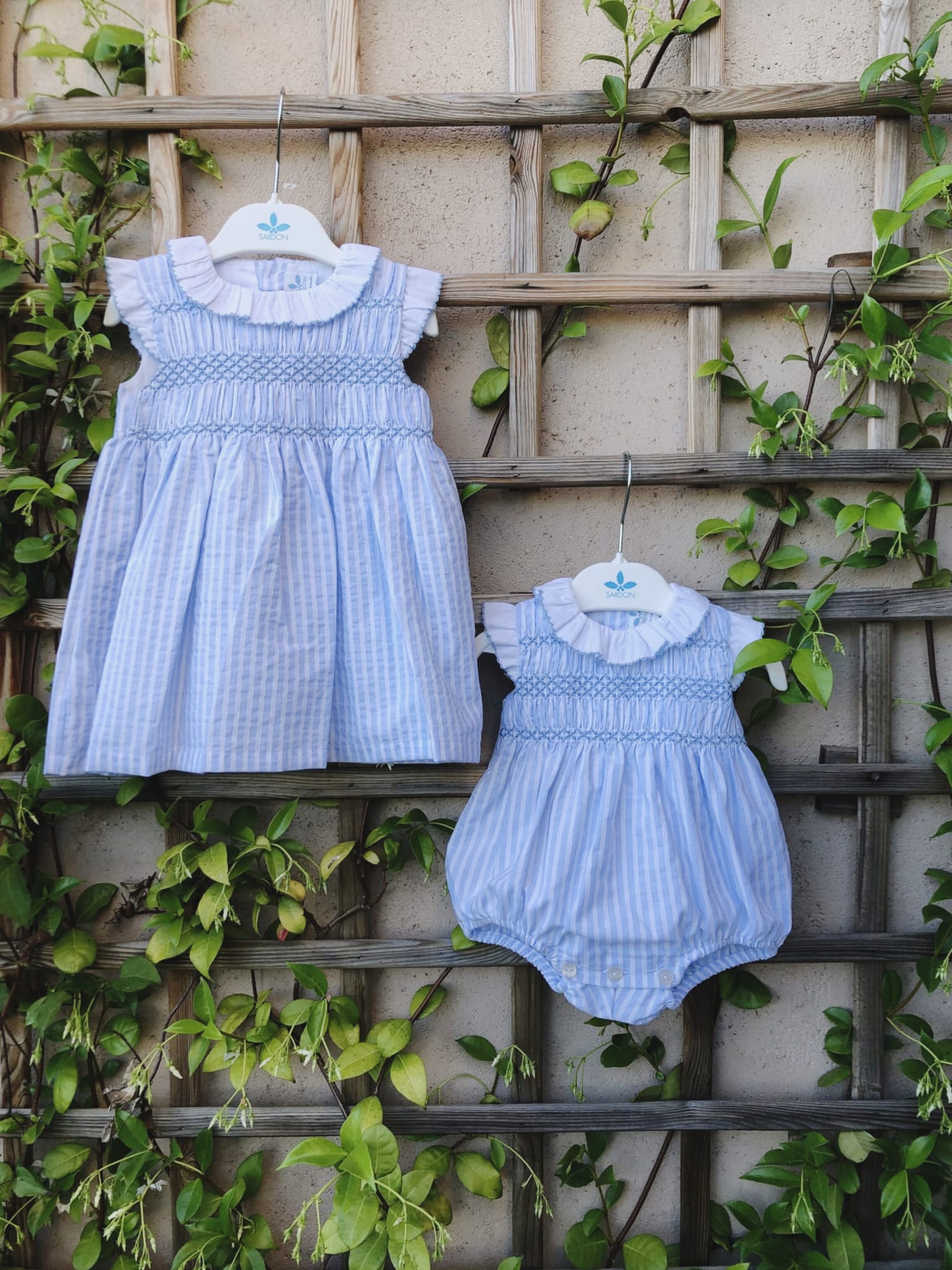 Colección Agatha, vestido y pelele a rayas blanco y celeste con punto smock bordado en el delantero