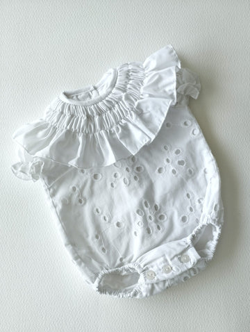 Pelele blanco de algodón bordado con cuello fruncido y manguita corta, va forrado en su interior.