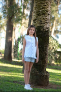 Conjunto en vichy celeste y blanco con camisa sin mangas y volante en cuello y en la parte inferior a juego con bermudas en color celeste.