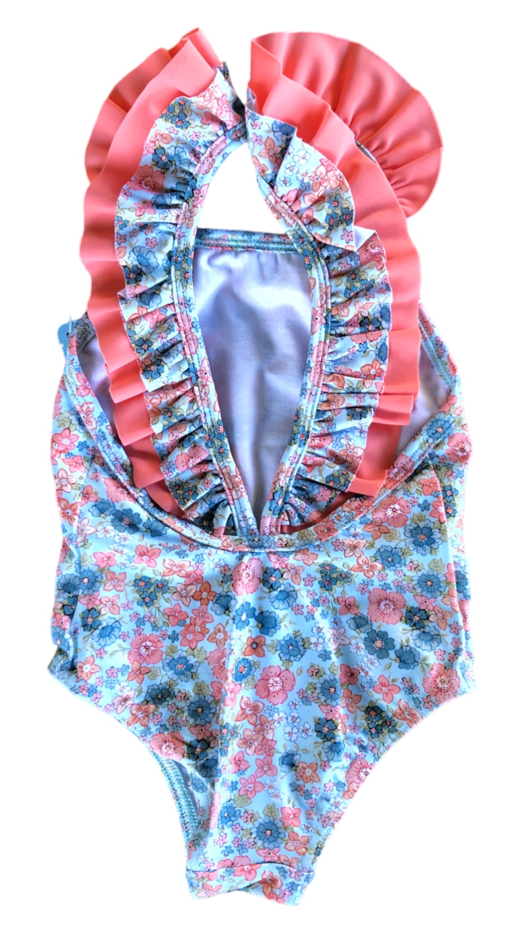 bañador coral para niña con florecitas sobre fondo azul claro y volante color coral en delantero y tirantes