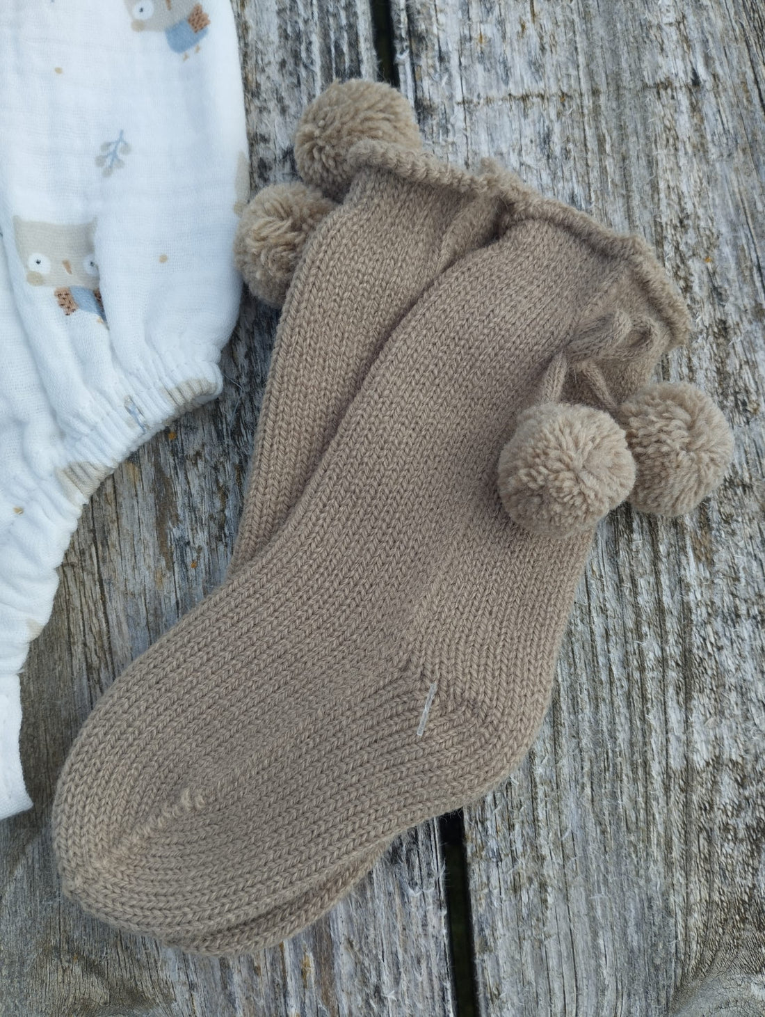 Calcetines con pompones en un elegante color Tostado  perfectos para mantener a los pequeños abrigados y con estilo durante los días fríos. Perfectos para combinar con la colección buhos