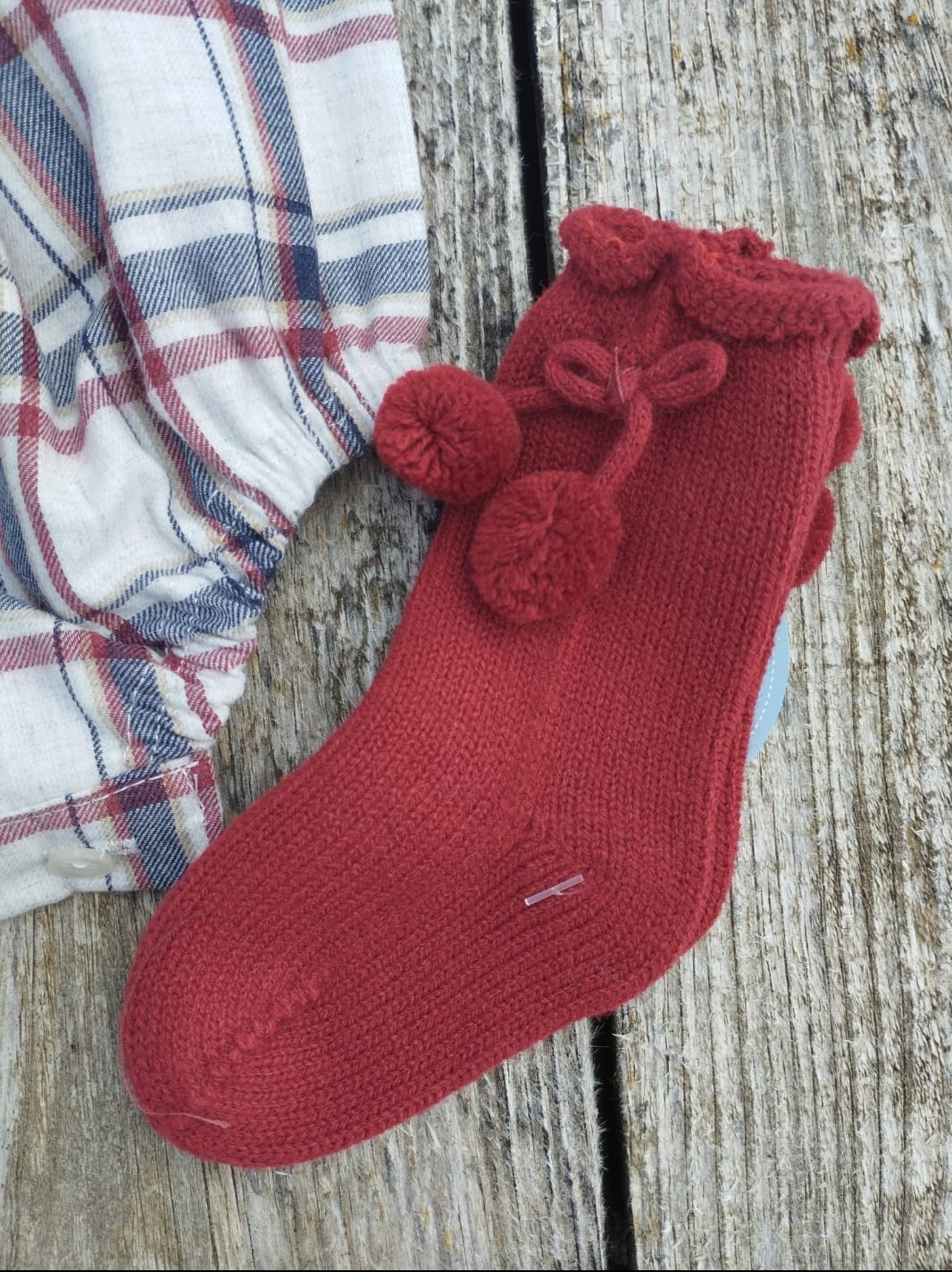 Calcetines con pompones en un elegante color Rioja  perfectos para mantener a los pequeños abrigados y con estilo durante los días fríos. Perfectos para combinar con la colección escocés.