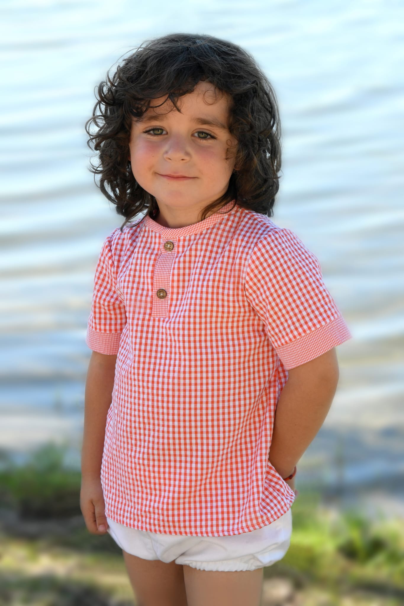 Camisa vichy niño Lili, en color coral y blanco de manguita corta y abrochada en el delantero con dos botones de madera.