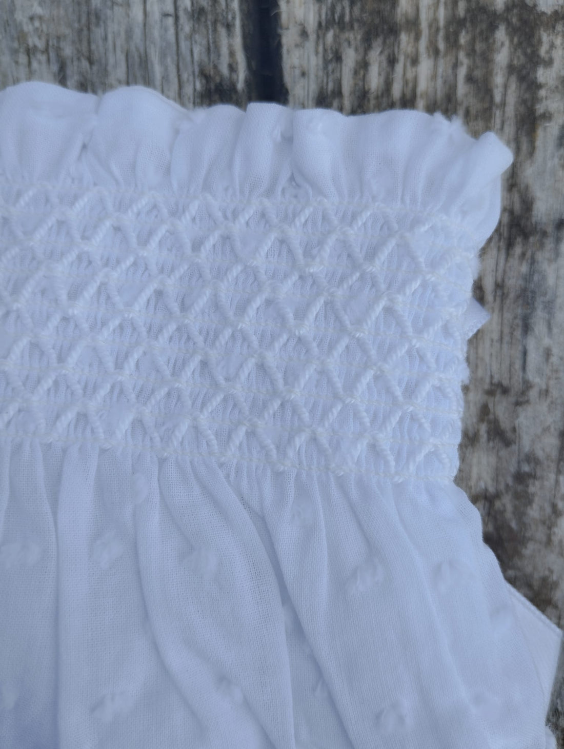 Cubrepañal plumeti en color blanco con punto smock, va forradito en su interior , un básico atemporal ideal en verano como en invierno con unos leotardos.