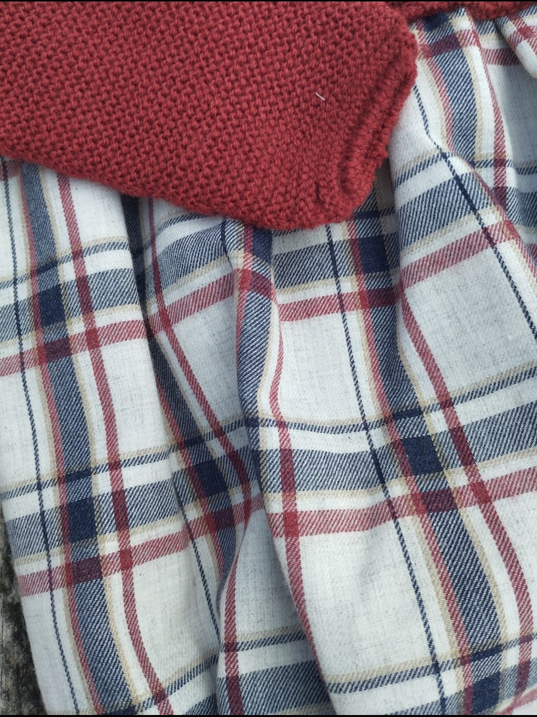 Este pelele combina la suavidad de la lana con un diseño encantador de tela estampada en cuadros escoceses. 