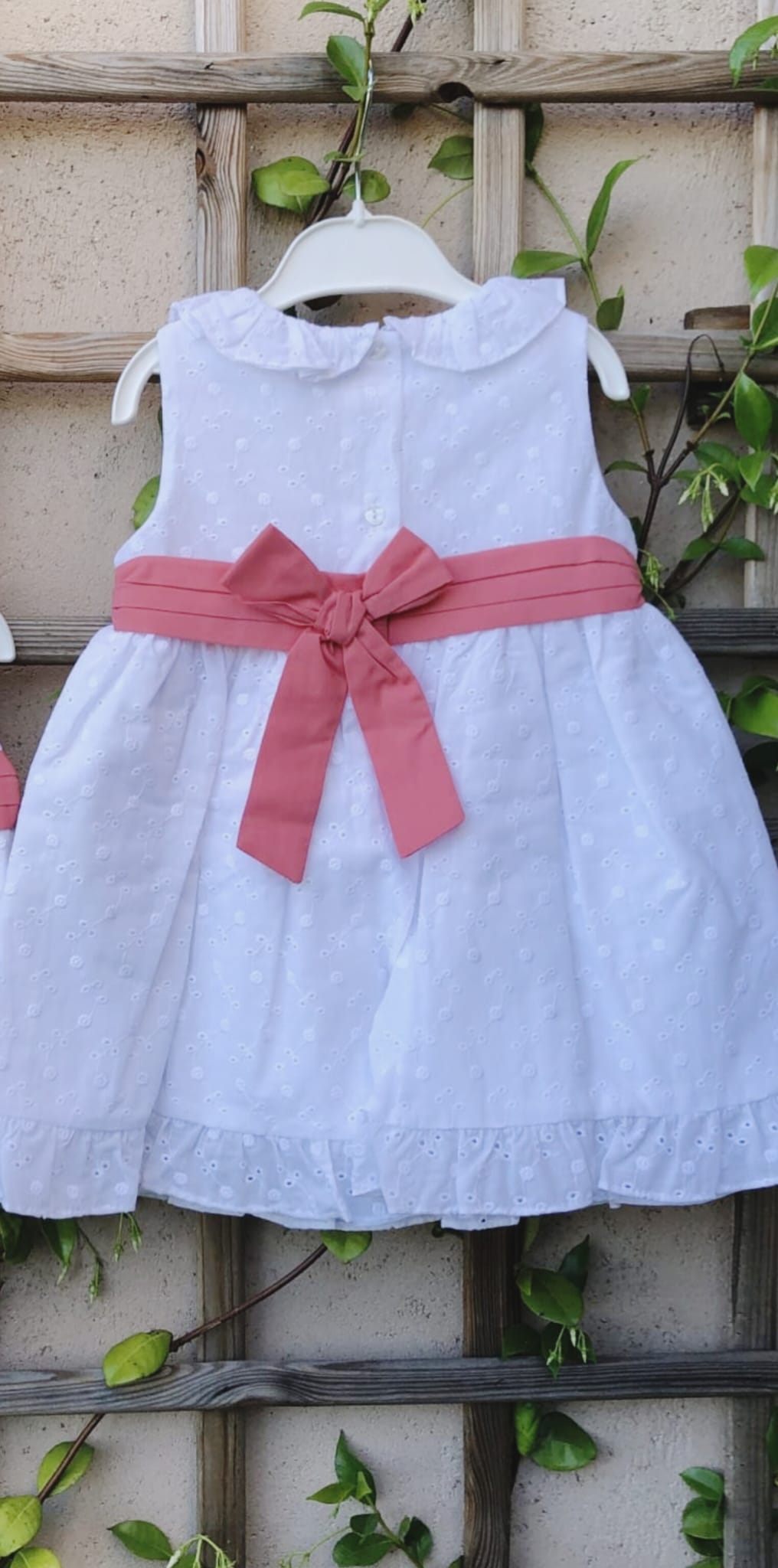 vestido candela en algodón 100% bordado y perforado color blanco con fajin coral anudado en la espalda con lazada.