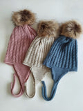 Mantén a tu peque abrigado y adorable con este gorro de punto en unos colores de ensueño azul plomo, rosa y arena. Su diseño con orejeras protege del frío y se ajusta cómodamente, asegurando que las orejitas estén siempre calentitas.