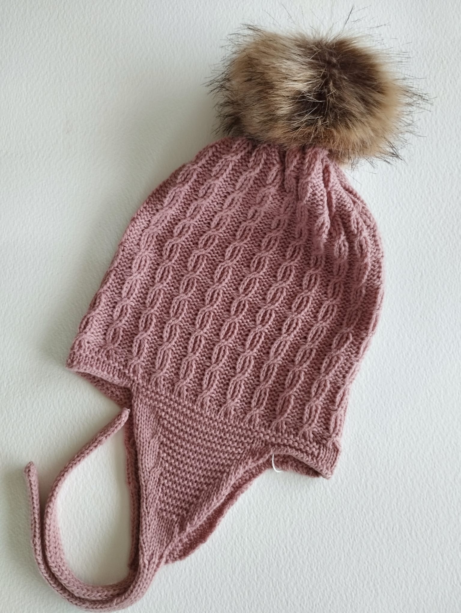 Mantén a tu peque abrigado y adorable con este gorro de punto en color Rosa empolvado. Su diseño con orejeras protege del frío y se ajusta cómodamente, asegurando que las orejitas estén siempre calentitas.