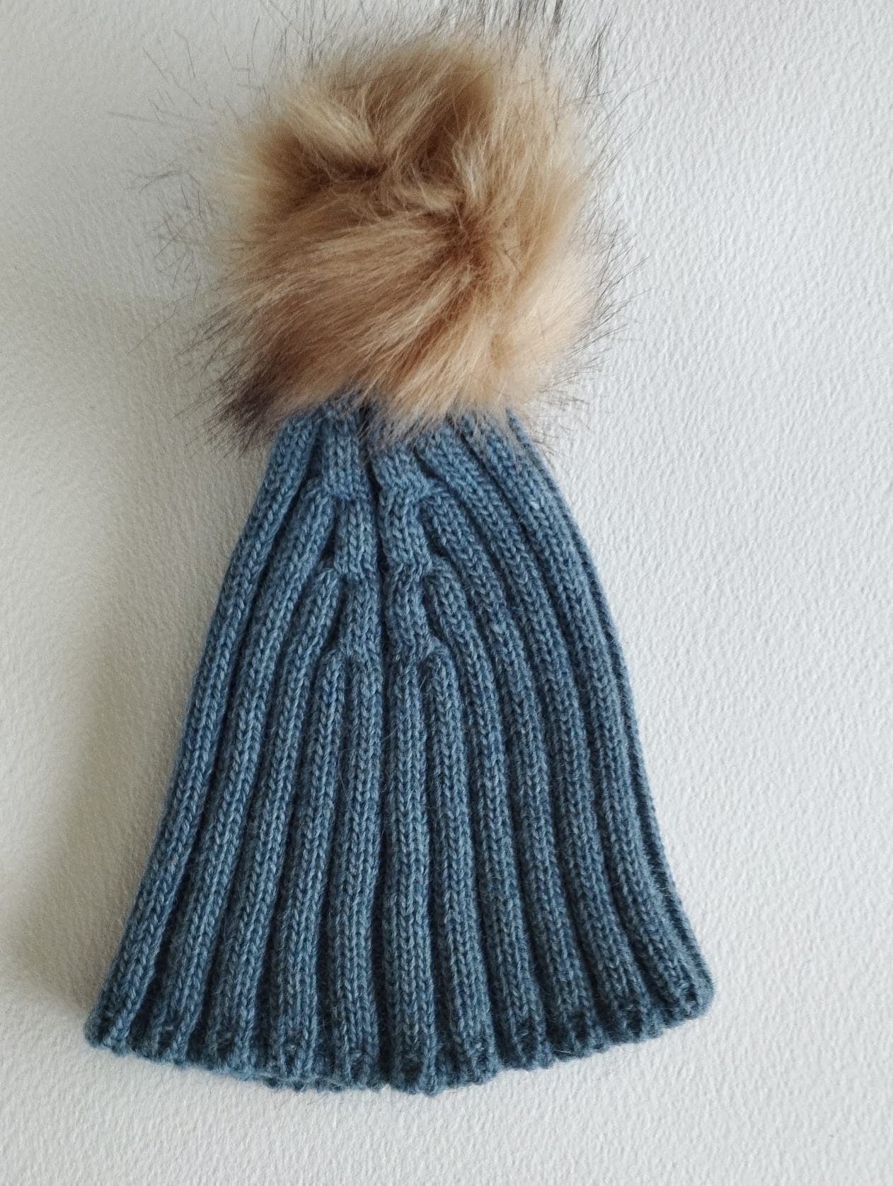 Este encantador gorro de punto, en un elegante color azul plomo, es perfecto para mantener a los pequeños abrigados y con estilo durante los días fríos.