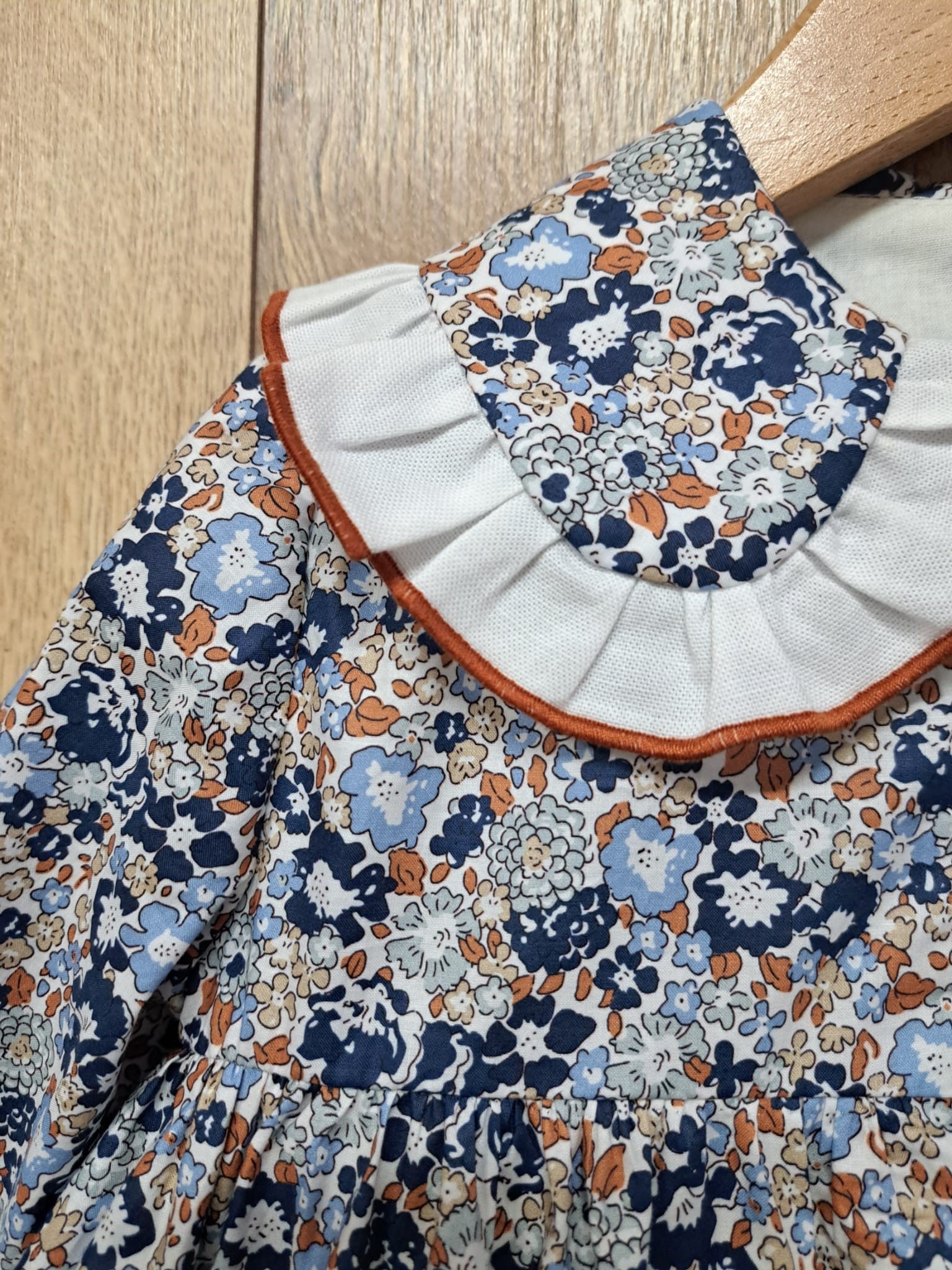Jesusito Marina, estampado en flores azules y caldera con cuello ribeteado y braguitas a juego. 69,95€