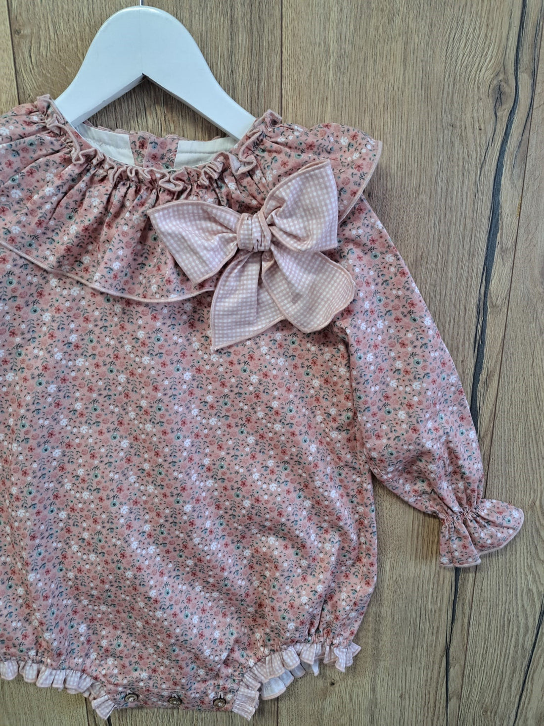 Pelele Daisy de Boetiekids, en flores rosas y blancas con cuello de volante, manguita larga fruncida en la muñeca una auténtica maravilla. 58,95€
