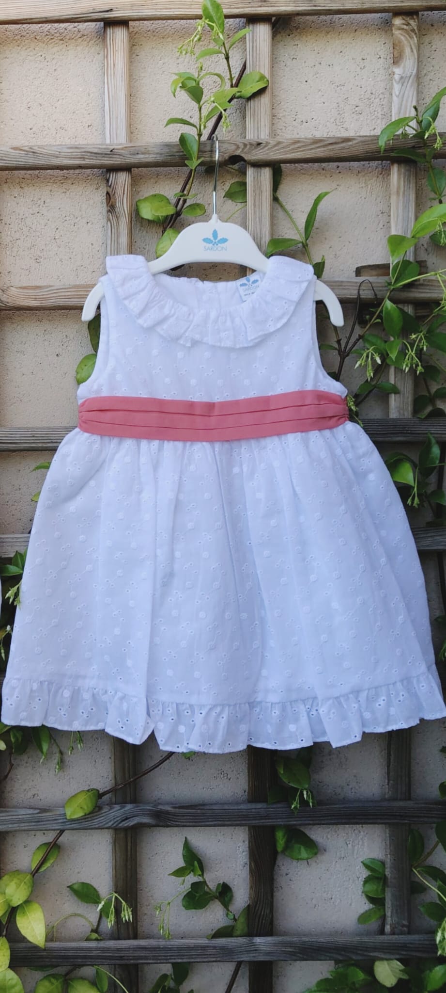 vestido candela en algodón 100% bordado y perforado color blanco con fajin coral anudado en la espalda con lazada.