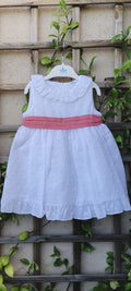 vestido candela en algodón 100% bordado y perforado color blanco con fajin coral anudado en la espalda con lazada.